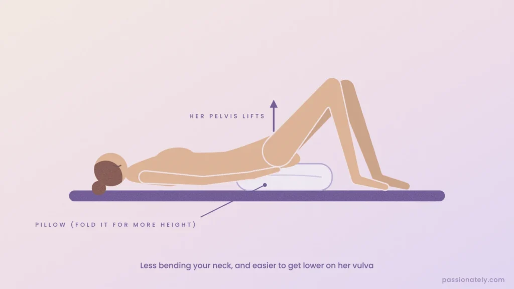 Side view of a woman lying on her back with a pillow under her bum lifting her pelvis